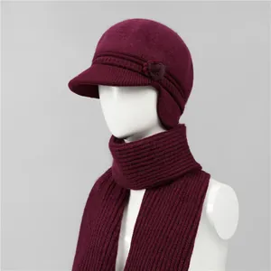 Detalle de gorro de punto color rojo vino con decoración floral y bufanda a juego