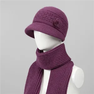 Detalle de gorro de lana tejido morado con flor y conjunto de bufanda de invierno