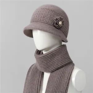 Detalle del conjunto de gorro cloche y bufanda de punto malva con flor de perla