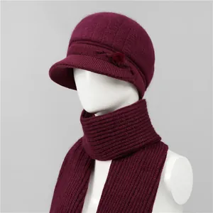 Detalle del conjunto de gorro y bufanda de punto burdeos con pompón y textura acanalada
