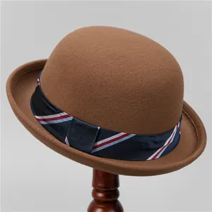 Detail of classic brown wool felt bowler hat featuring a navy ribbon on a wooden stand