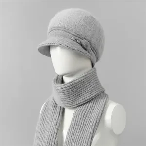 Detalle de conjunto de gorro y bufanda de punto gris con forro de piel y adorno