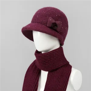 Detalle del conjunto de gorro y bufanda de punto rojo vino con lentejuelas y lazo para mujer
