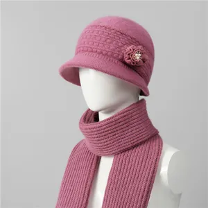 Detalle de gorro cloche de punto rosa con flor tejida y perla para mujer mayor