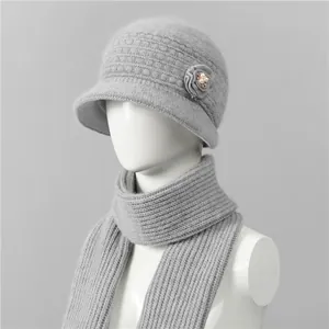 Detalle de gorro de punto gris con adorno floral y bufanda cálida a juego