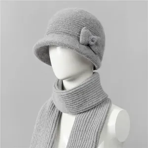 Detalle del conjunto de gorro y bufanda de punto gris con pelo de conejo y decoración
