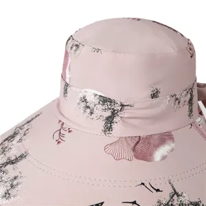 Dettaglio del cappello da sole rosa con stampa floreale a inchiostro e fiocco decorativo