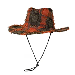 Detail of western cowboy hat featuring orange plaid patchwork and distressed frayed edges