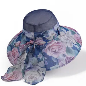 Detail of elegant sun hat showing blue mesh crown, floral brim, and large decorative bow