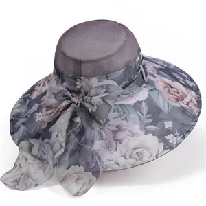 Detail of elegant gray sun hat featuring purple floral print and large bow embellishment
