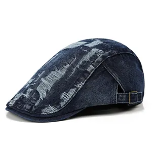 Detail einer blauen Denim-Baskenmütze mit Vintage-Löchern und Metallschnalle