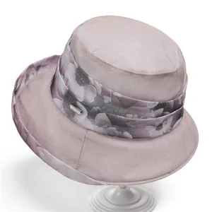 Detail view of pink organza sun hat featuring floral waist band and metallic emblem