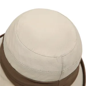 Detailed view of the pleated beige sun hat showing reinforced stitching and fabric texture