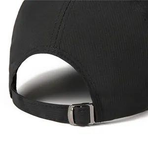Detail von atmungsaktivem Mesh-Gewebe und verstellbarer Metallschnalle an schwarzer Kappe