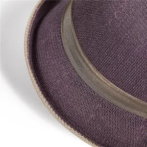 Detailaufnahme des lila geflochtenen Sonnenhutes mit Strohtextur und Satin-Dekorband