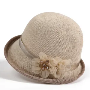 Detail der eleganten beigen Netzblume und Perlenverzierung auf dem Sonnenhut