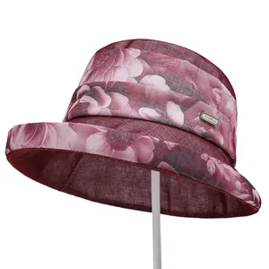 Detailed view of burgundy organza sun hat featuring pink flowers and fashion metal tag