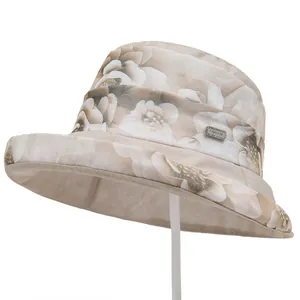 Detailed close-up of the elegant floral organza fabric and metal fashion label on the hat