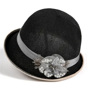 Detail of elegant mesh flower and pearl embellishment on black summer cloche hat
