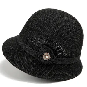 Detailansicht eines schwarzen Sonnenhutes mit eleganter Perlen- und Strassblumenverzierung