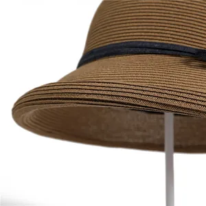 Hepburn style woven straw sun hat in brown with a black ribbon and curved brim