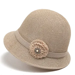 Detail eines beigen Strickhutes mit Blumenakzent, Perle und glitzernden Strasssteinen