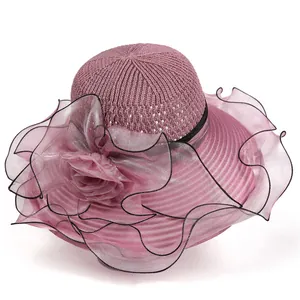 Détail d'un élégant chapeau de soleil rose avec haut tissé et fleur délicate en organza