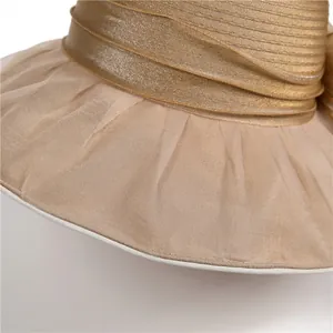 Detail of elegant champagne sun hat with sheer organza brim and metallic decorative band