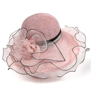 Détail d'un élégant chapeau de soleil rose avec fleur d'organza et maille respirante