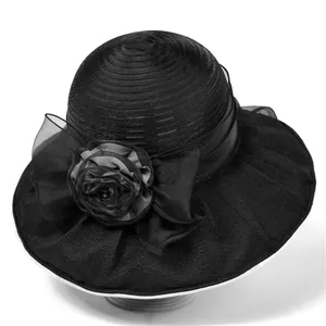 Detail of elegant black sun hat with large organza bow and 3D floral accent decoration
