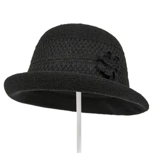 Λεπτομέρεια από μαύρο πλεκτό καπέλο cloche με κομψό λουλούδι και ανάγλυφη ύφανση