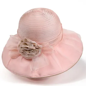 Detail of light pink organza sun hat with elegant fabric rose and pearl accents