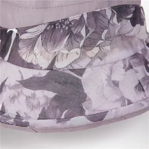 Detalle de sombrero de sol lila con estampados florales y textura de tela satinada