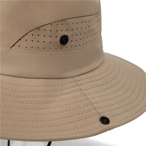 Close-up of khaki outdoor sun hat featuring side ventilation holes and snap buttons