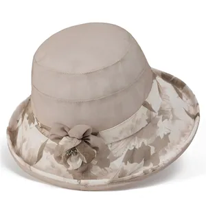 Detalle de sombrero de sol caqui con motivos florales y una flor de tela decorativa