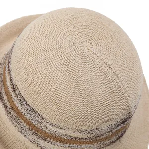 Top view of beige straw sun hat with woven spiral texture and striped decorative band