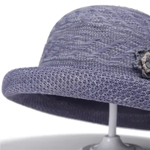 Detailed close-up of purple knit sun hat with floral ornament and mesh texture