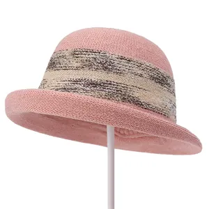 Detail of pink knitted cloche hat featuring decorative beige and brown stripes