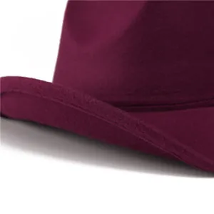 Dettaglio del cappello di lana bordeaux con cucitura a doppio filo e trama in feltro