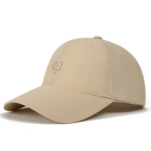 Detailed view of the embroidered shield logo and quick-dry fabric on this beige cap