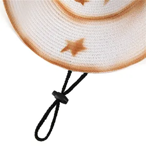 Dettaglio di un cappello da cowboy in paglia intrecciata con motivo a stelle e sottogola
