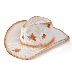 Dettaglio cappello cowboy in paglia con motivi a stella marroni e trama traspirante