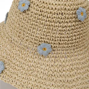 Straw beach hat with large brim and delicate blue flower embroidery detail for summer
