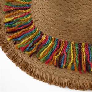 Straw beach hat with colorful rainbow tassels and bohemian fringe details for vacation