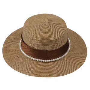 Détail d'un chapeau de paille à sommet plat avec perles et ruban de satin brun