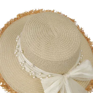 Flat top straw hat with pearls, bow mesh, and frayed brim for beach sun protection