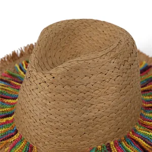 Close-up of bohemian straw hat showing colorful wavy tassel details and woven texture