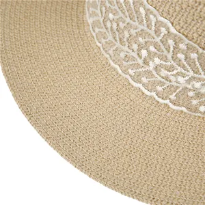 Close-up of woven straw hat texture with white lace embroidery detail and wave pattern