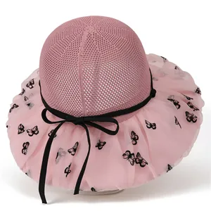 Detail of pink sun hat with wide mesh brim featuring black butterfly patterns and bow