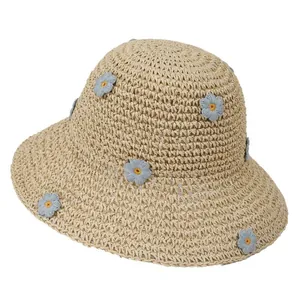 Women's wide brim straw sun hat with light blue knit flowers for summer beach vacations